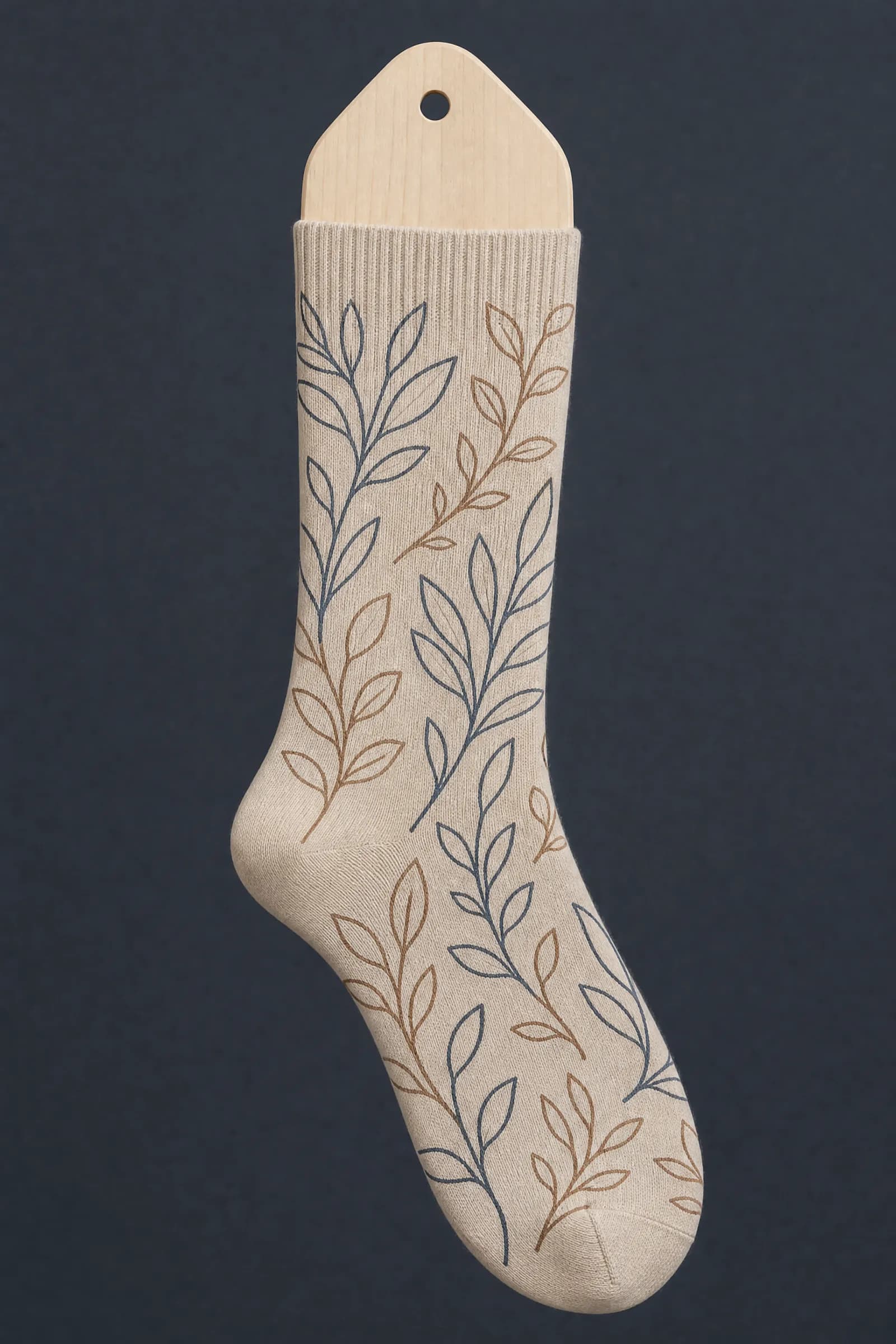 The Leaf Line pattern on a sock stretched over a sock form, showing how the drawing curves and compresses