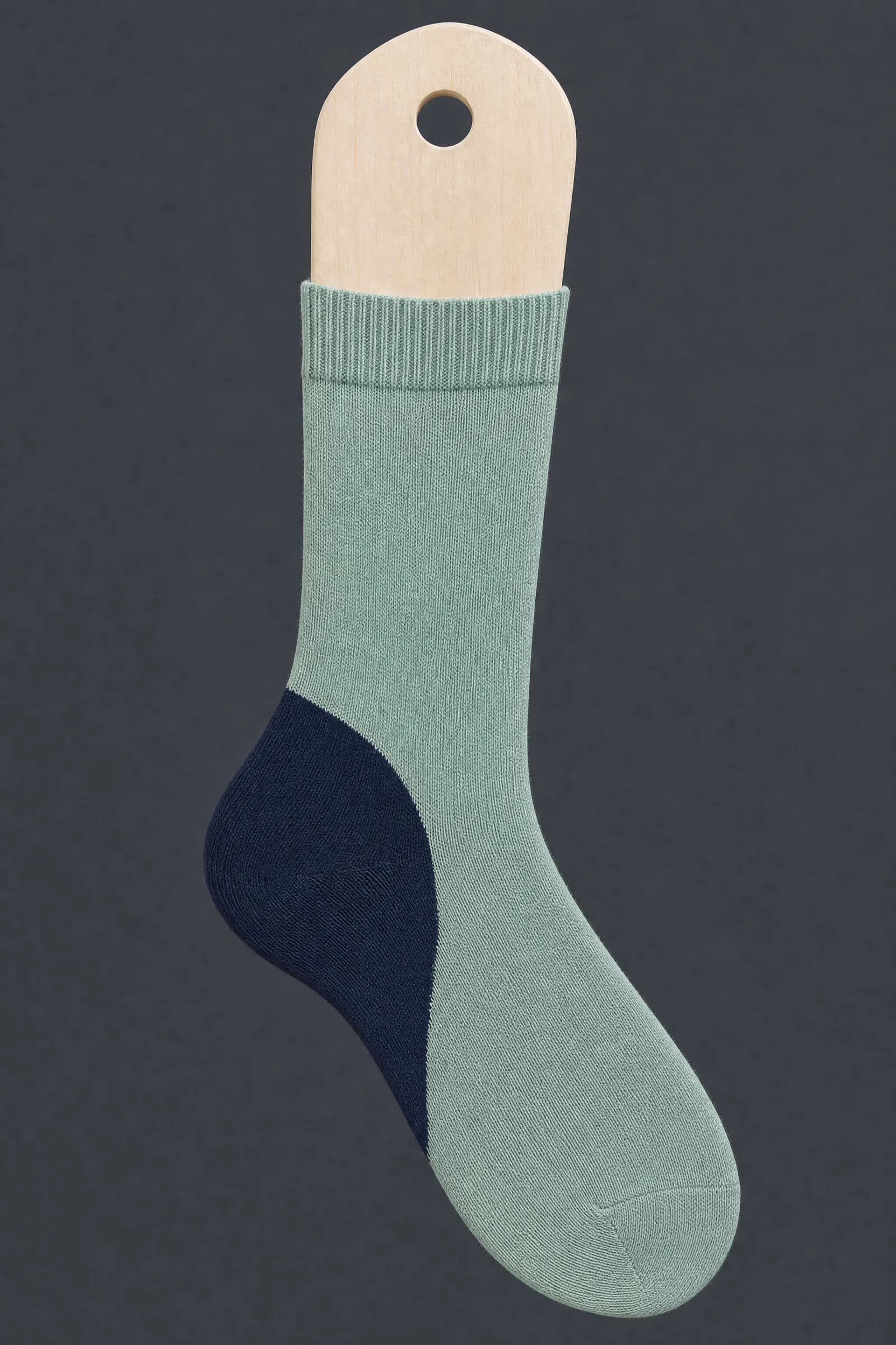 The Split Heel pattern on a sock stretched over a sock form, showing how the drawing curves and compresses