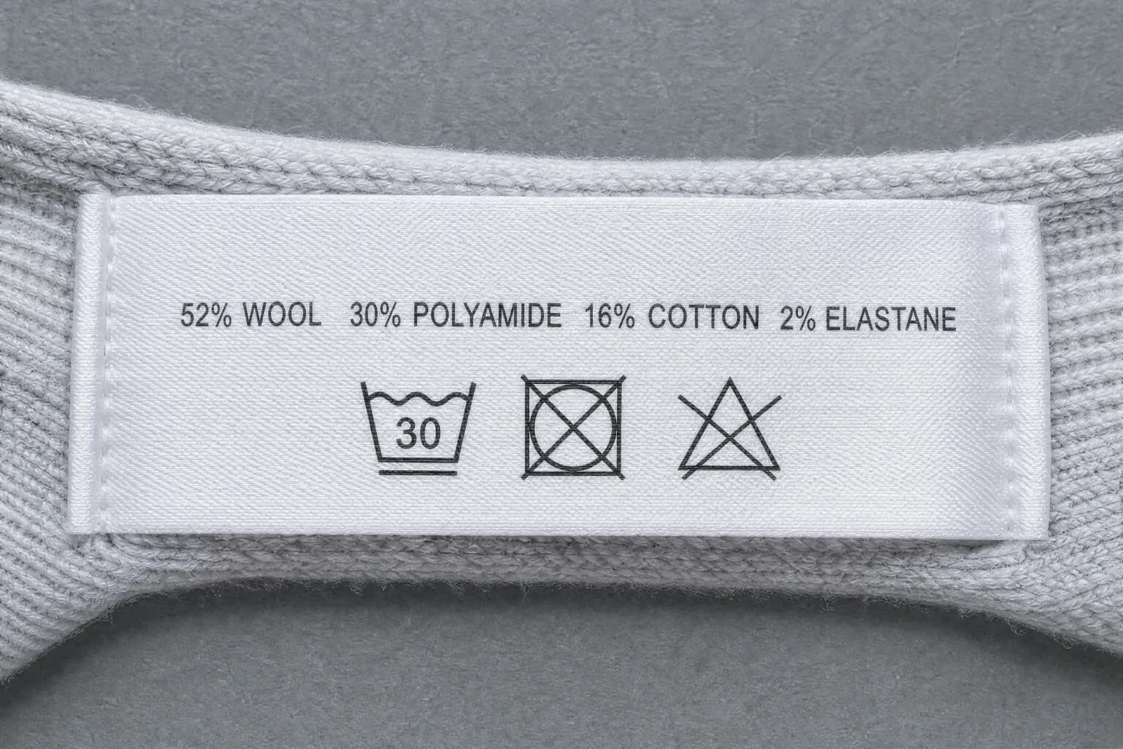 The sewn-in care label for Illusion Premium, showing the fibre composition and wash symbols